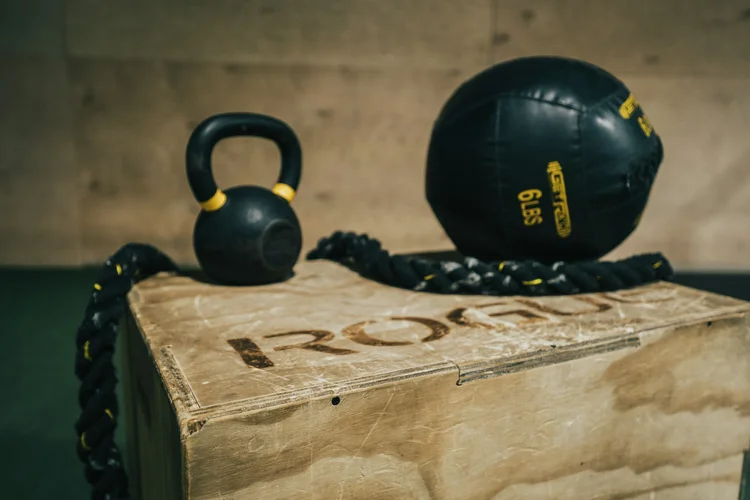 Kettlebell, medicinbold og battle rope på en trækasse